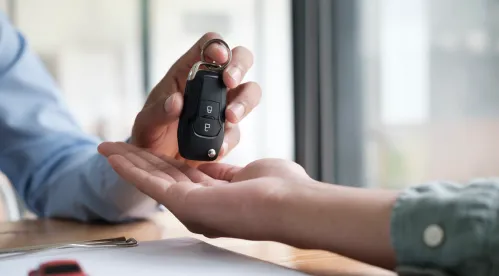 une personne qui remet une clé de voiture