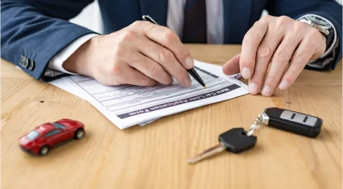 une personne signant un formulaire de prêt automobile